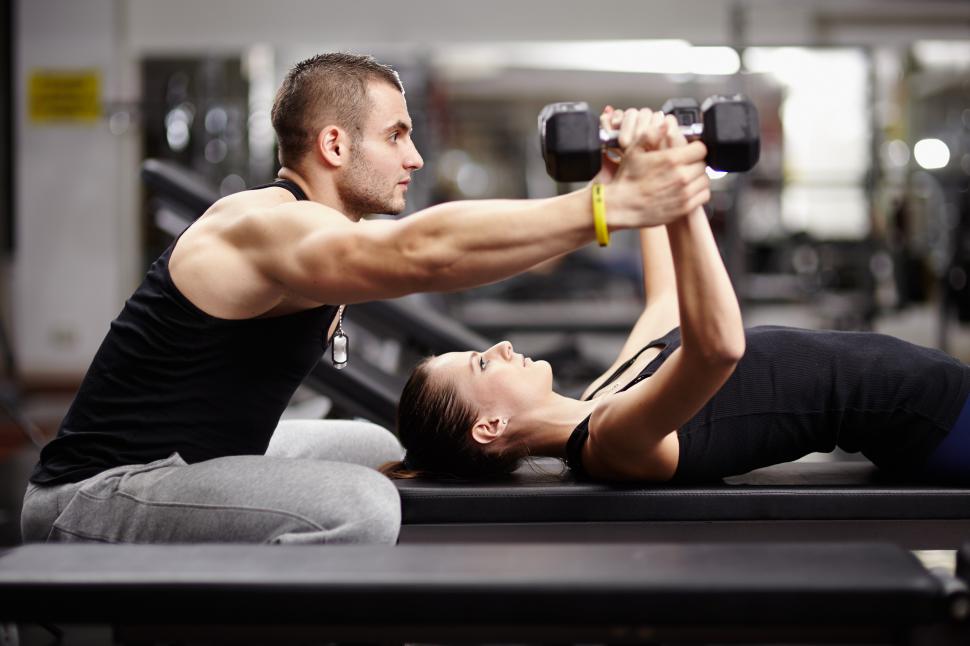 personal trainer training a female gym goer