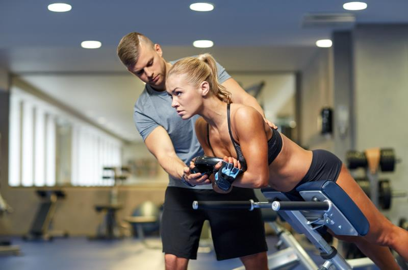 woman gym goer with a personal trainer
