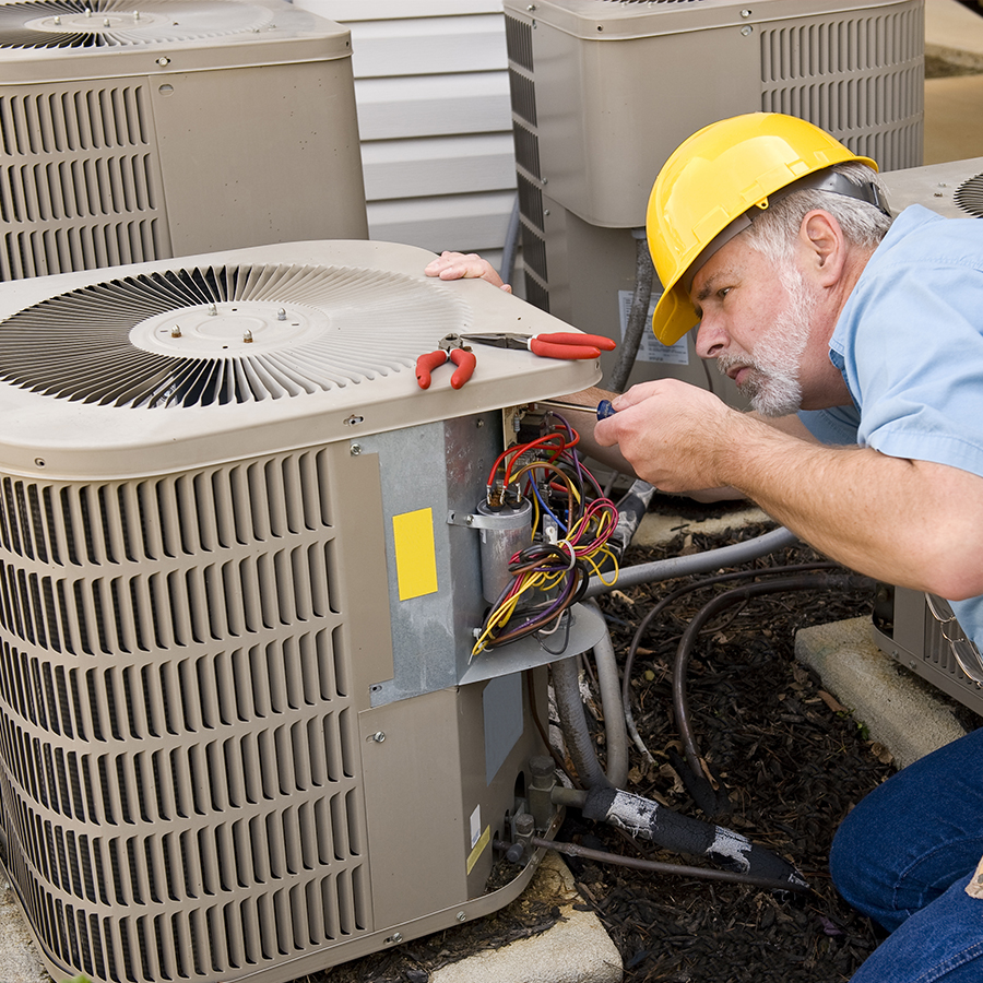 Technician fixing noisy aircon compressor