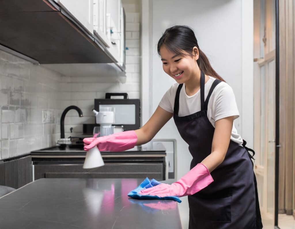 Professional cleaner wiping down a kitchen top