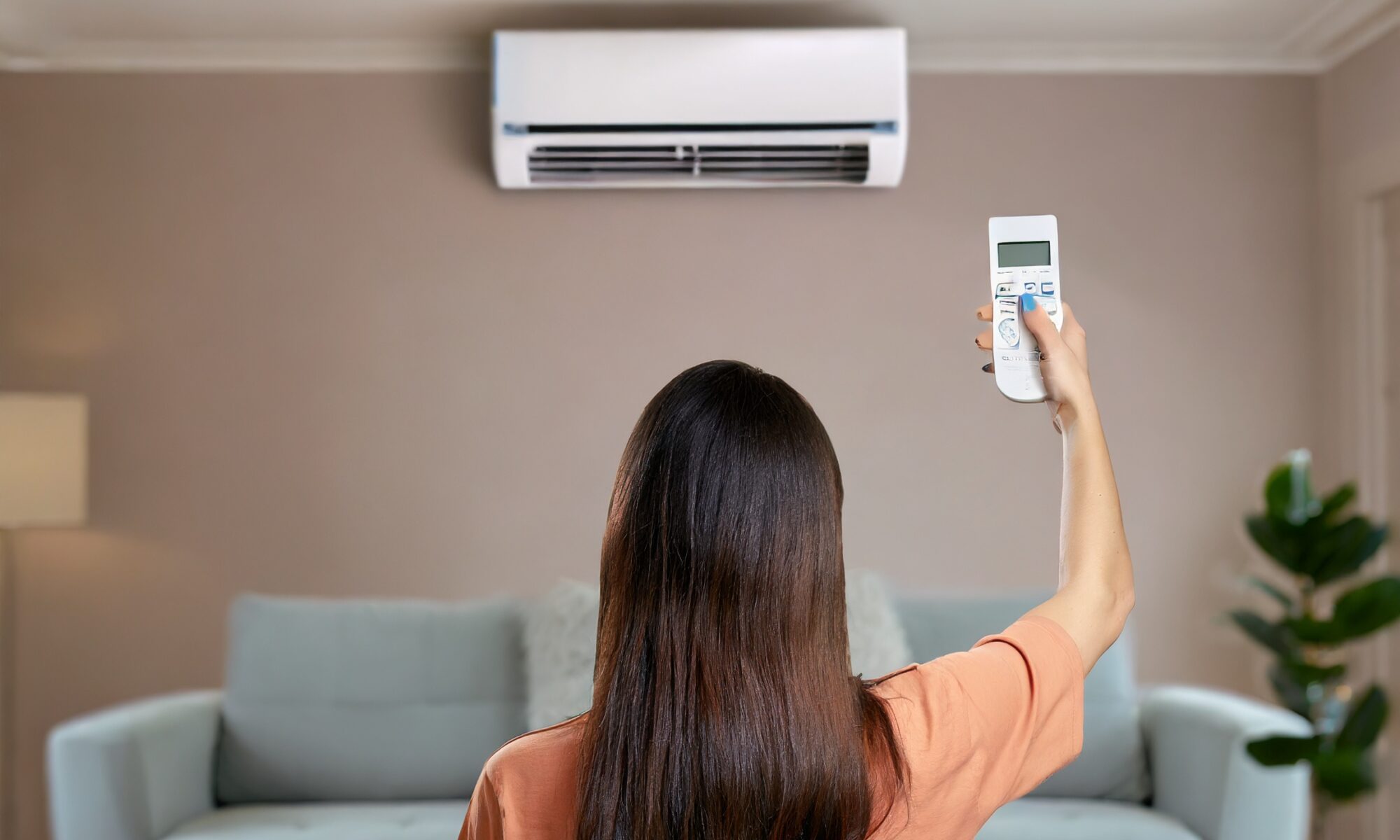 woman adjusting the temperature of an aircon in living room