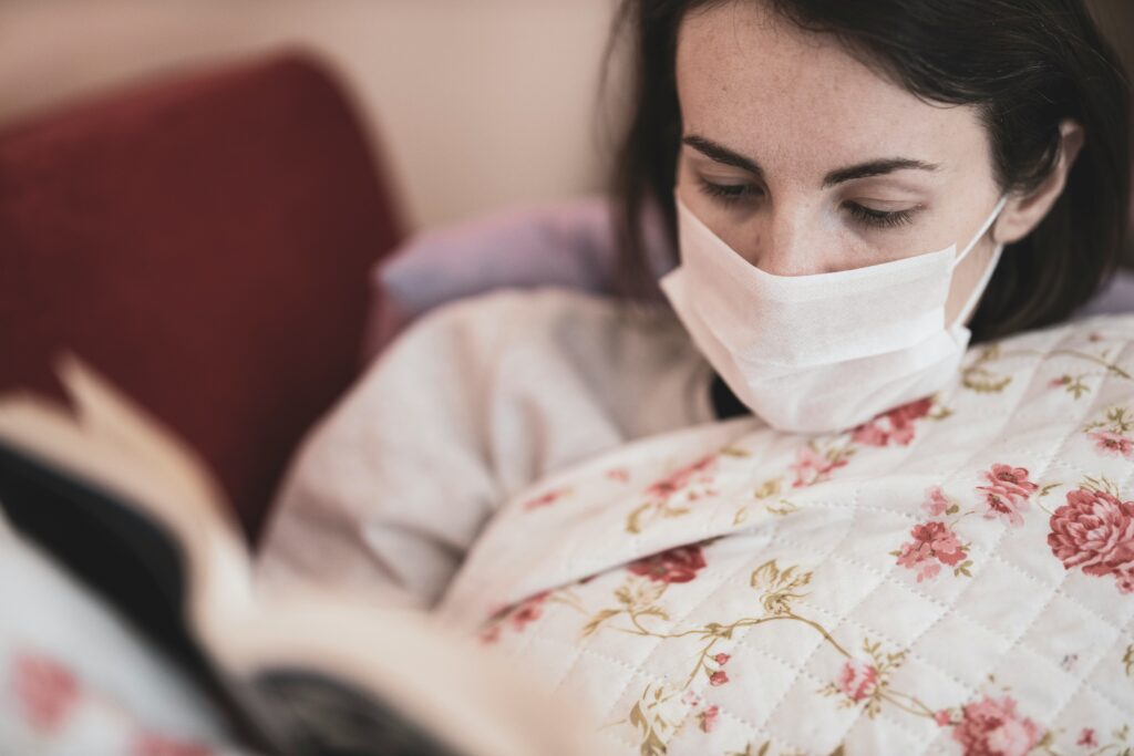 sick woman lying down in bed