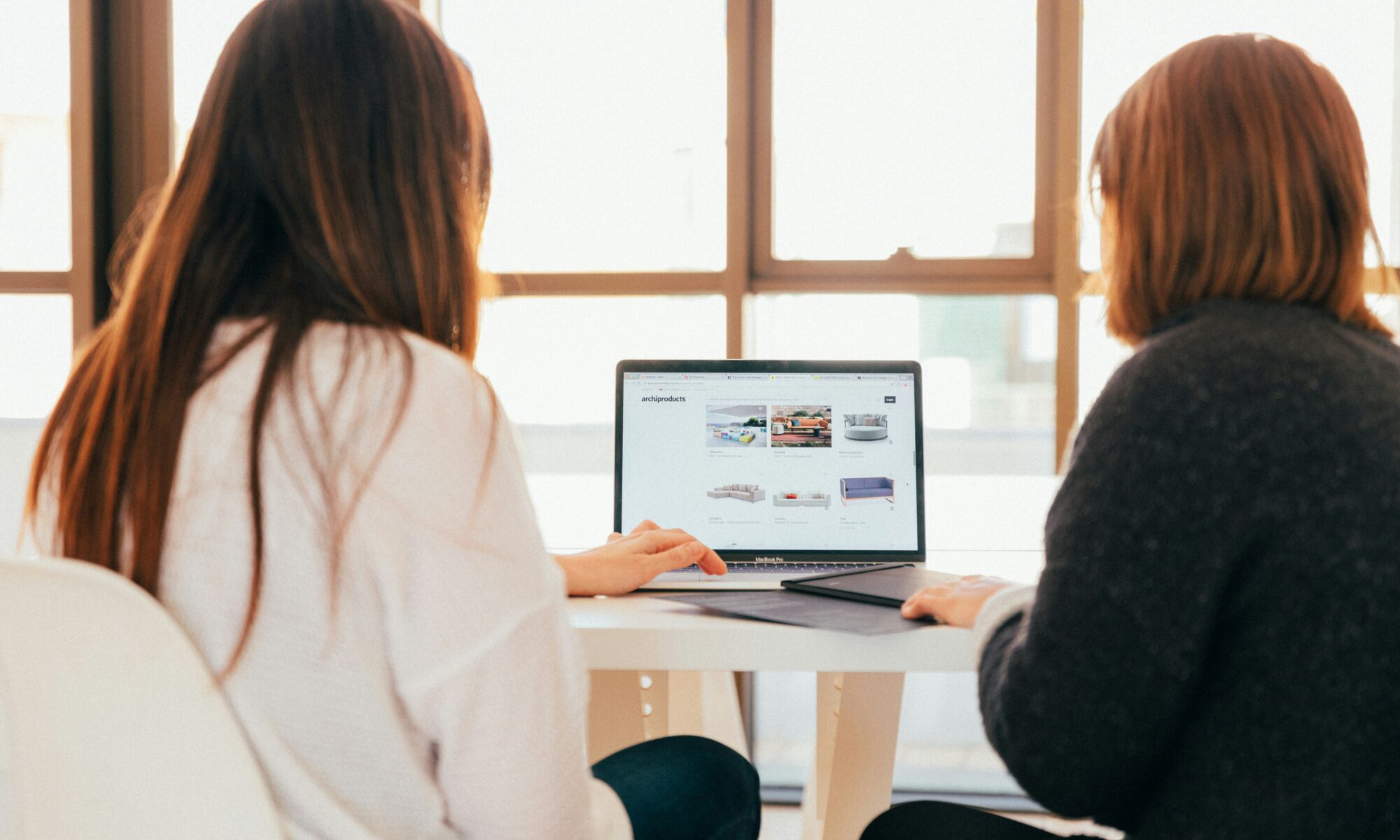 two women working on a laptop together