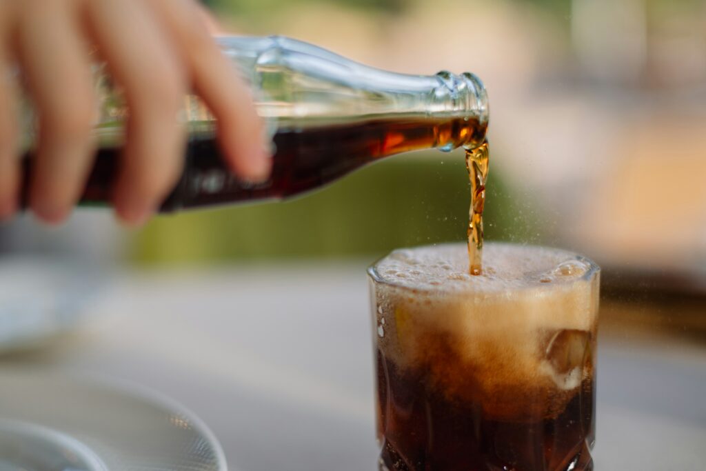 pouring carbonated drink into a glass 