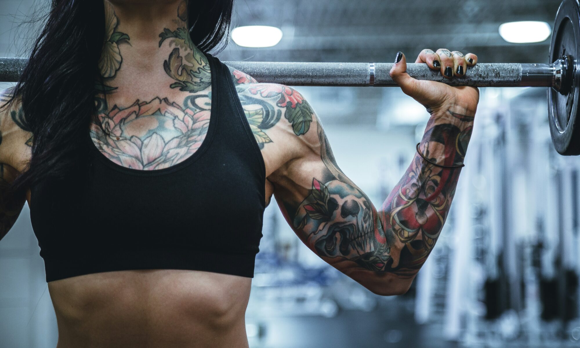 tattooed woman carrying weights