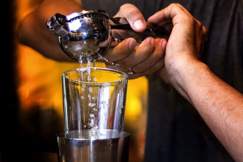 image of someone squeezing fresh lemon juice into a glass